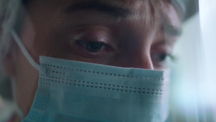 A woman is wearing a face mask and face shield