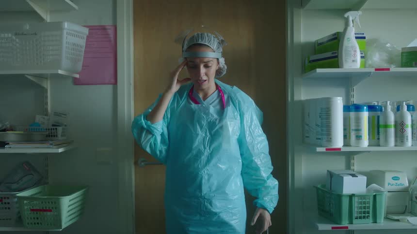 A woman taking off a mask in a hospital