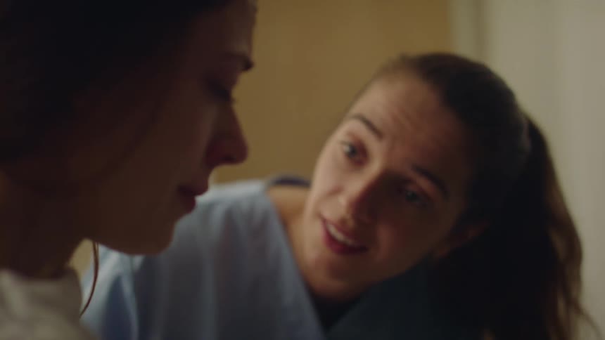 A nurse talks to and tries to comfort a crying patient