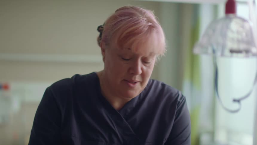 A nurse speaks to a patient in a hospital room