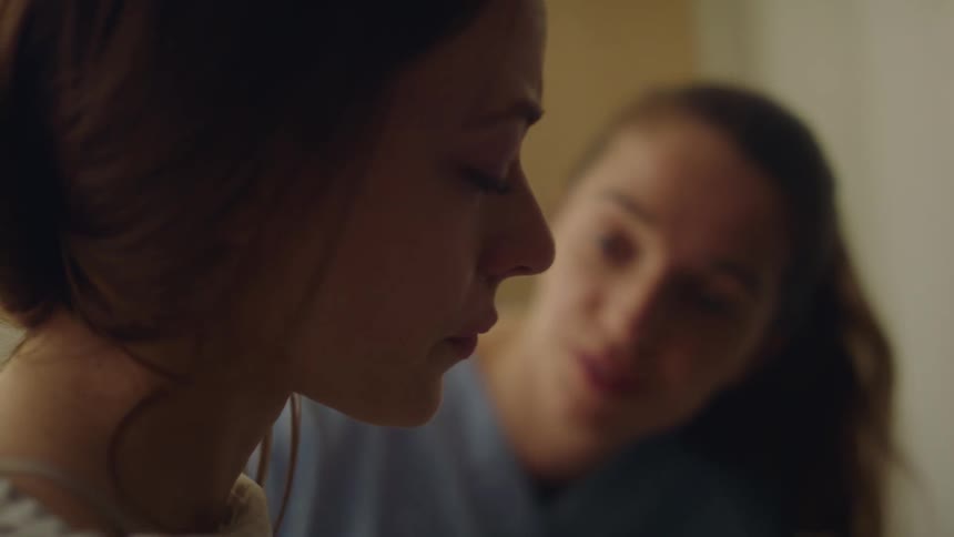 Nurse helping and consoling a sad patient in a hospital room