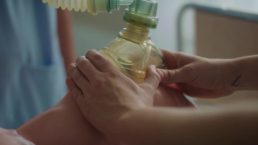 Two nurses are learning and practicing medical care on a mannequin in a hospital setting