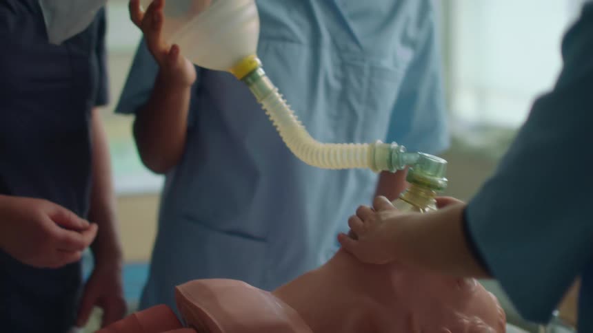 A woman is teaching doctors on a dummy