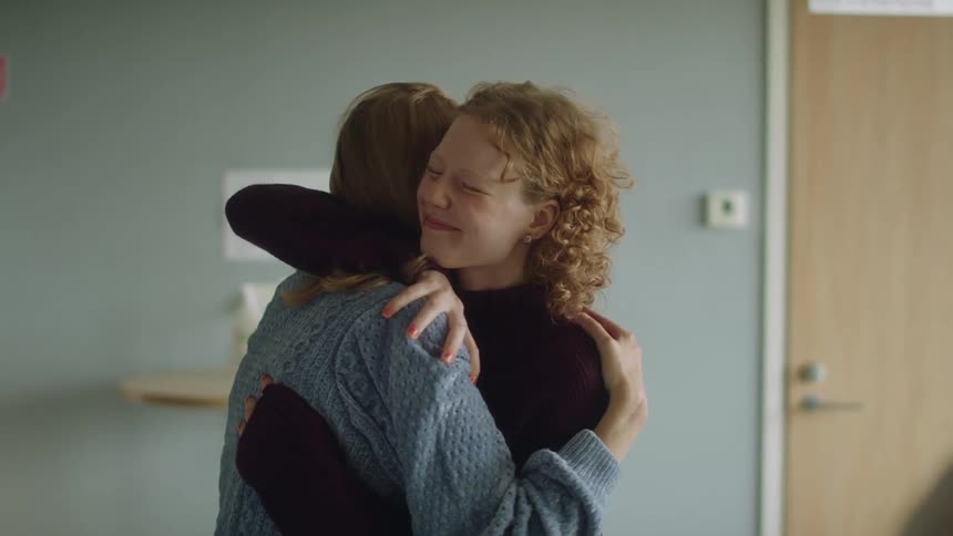Worried women laugh and hug in relief hearing the doctor prognosis