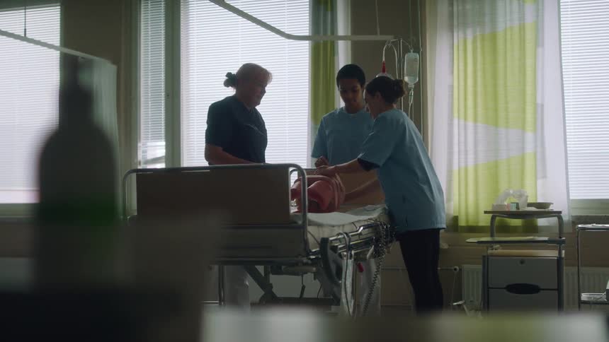 Doctors and nurses practicing over a bed on the hospital room