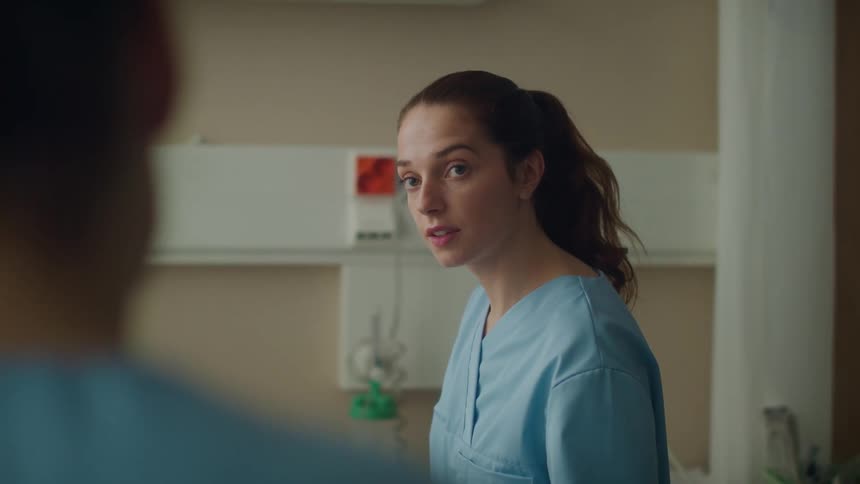 Young nurse in training inside a hospital room talking