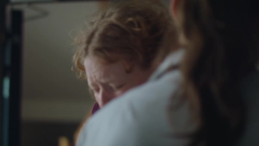 A woman is sobbing and crying and another woman hugs her