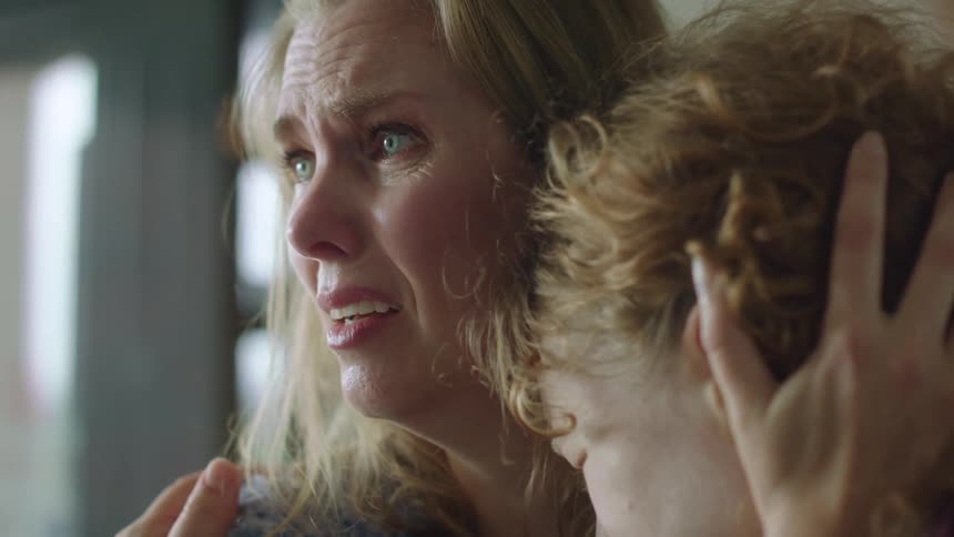 A mother hugs her daughter as they cry