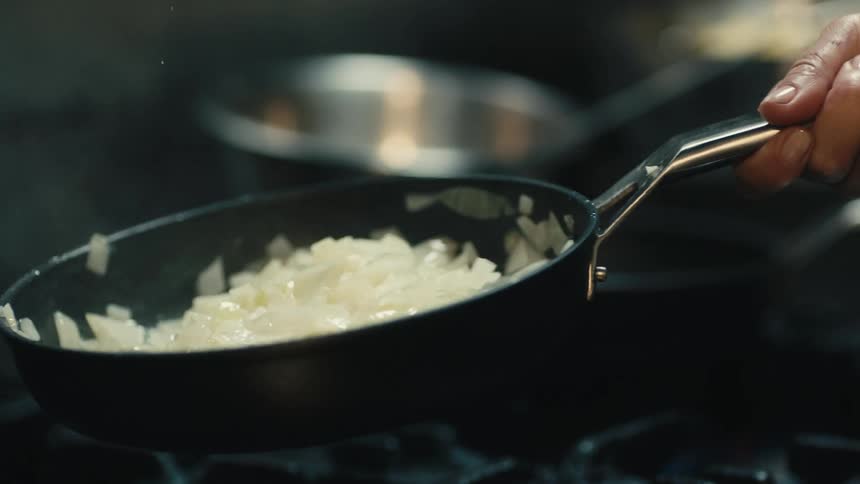 A person is flipping food in the pan