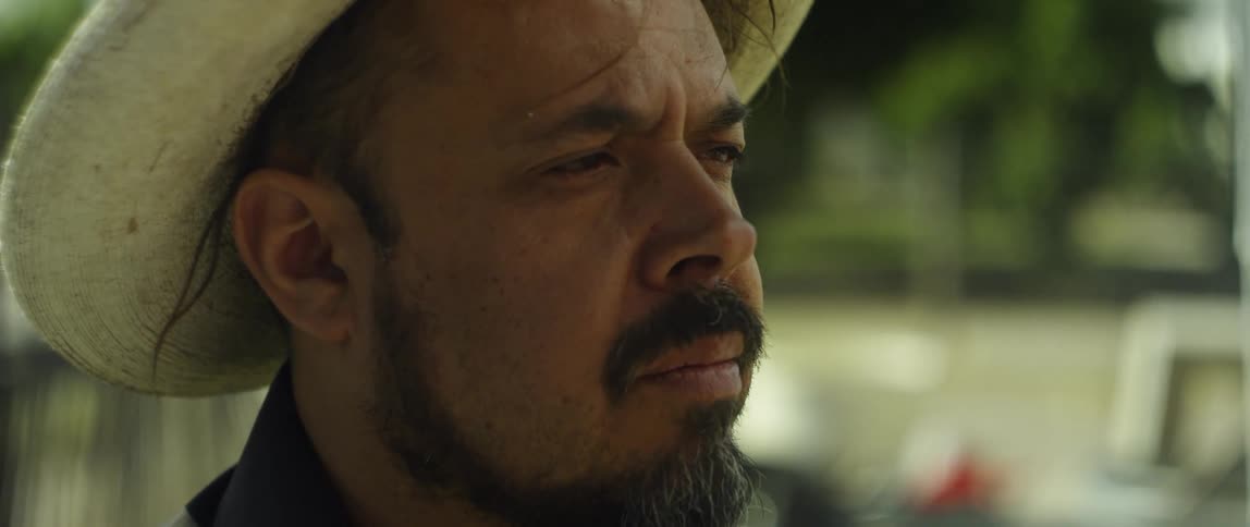A man is wearing a sombrero and looking forward