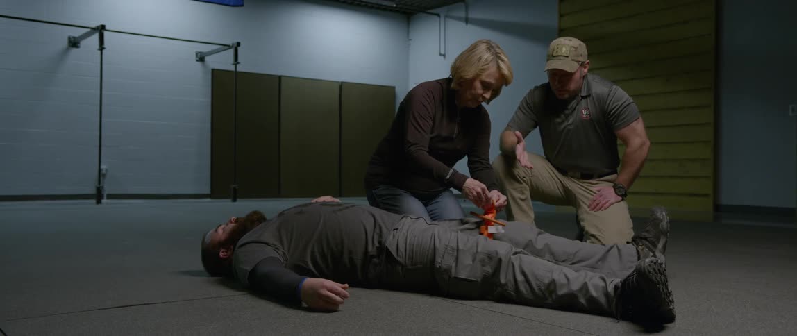 A woman wraps a bandage around a man's leg