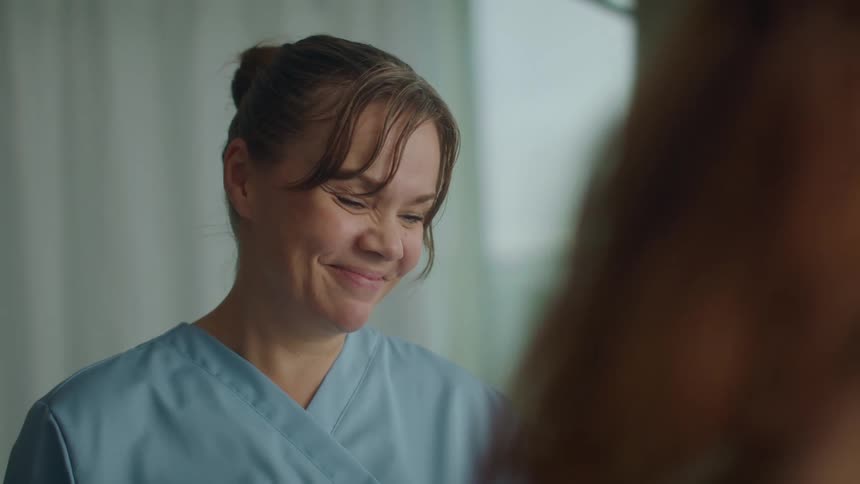 A nurse is talking to someone and nodding her head