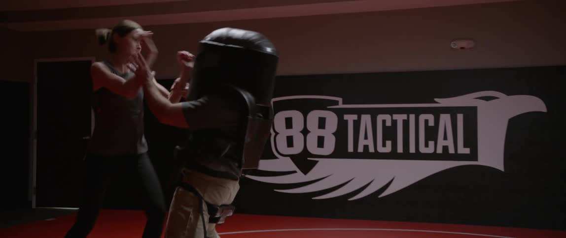 Two people are sparring in a gym