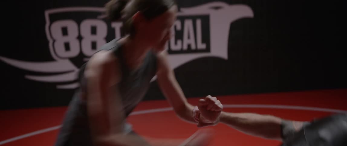 Two people are sparring in a gym