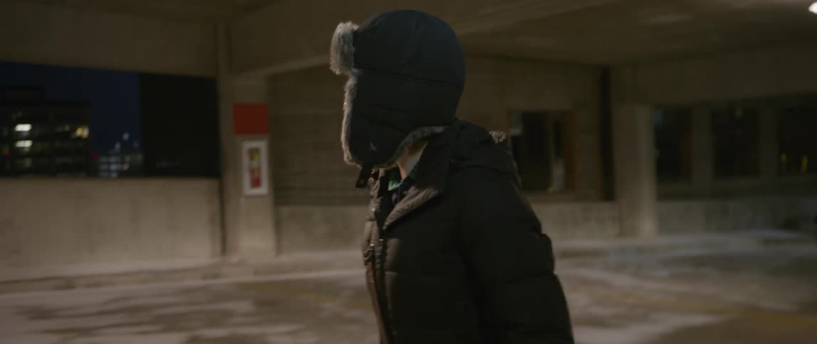 A woman walks through a parking garage