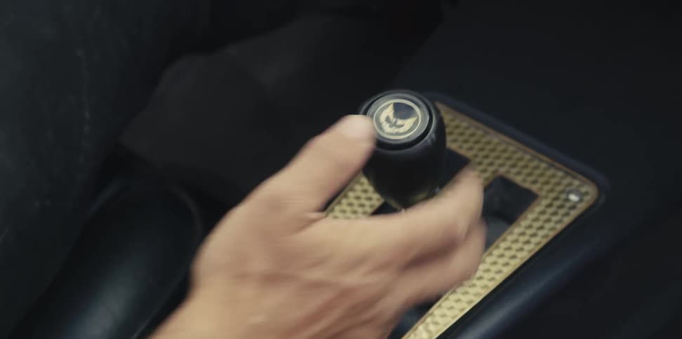 A man shifts gears while driving a luxury vehicle