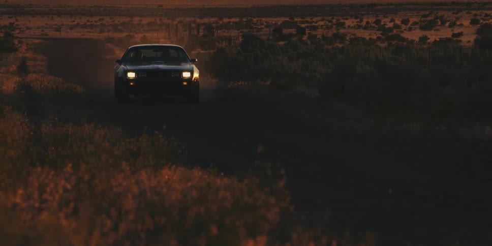 A car driving on a dirt road in the desert