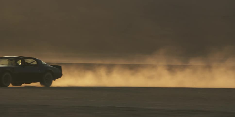 A car driving on a desert landscape