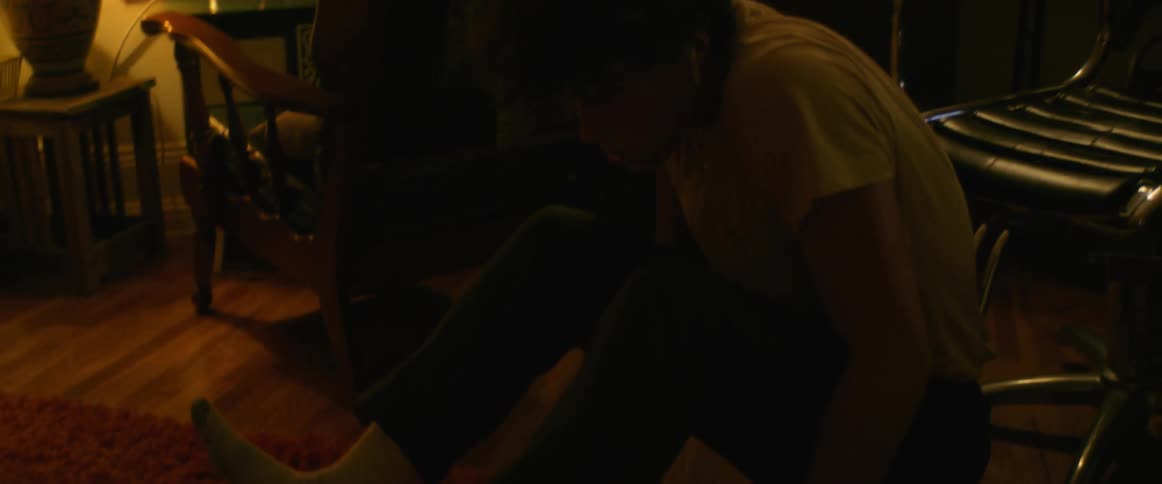 Young man slides down from a chair and starts rolling and dancing on the floor