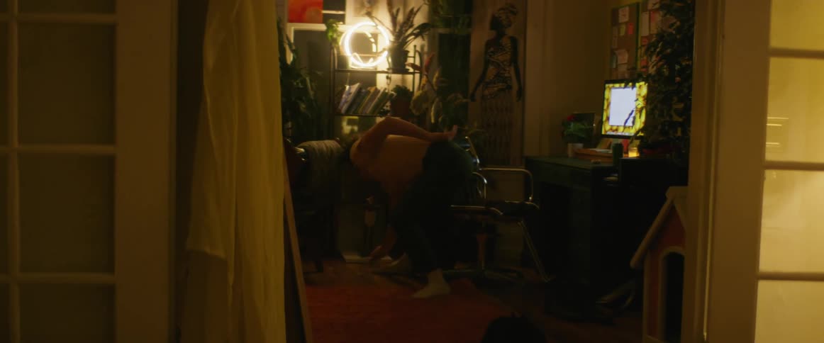 A man in a room dancing with a wall and windows in the background