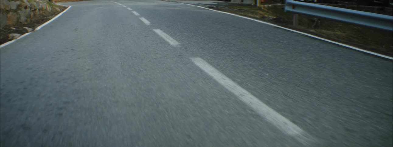 A rear facing view of traveling along a road during the daytime