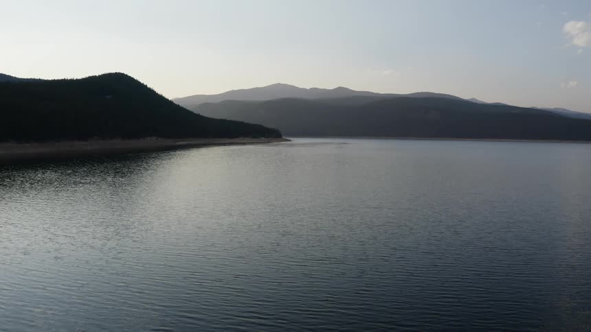 Gentle waves ripple in the ocean near mountains
