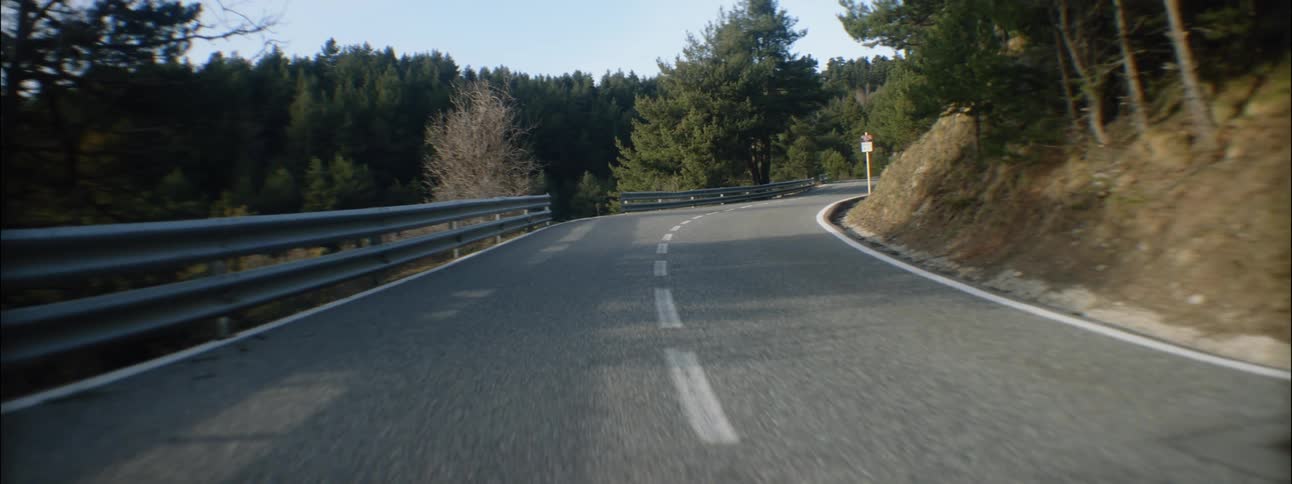 A guardrail sits along the edge of a rural highway