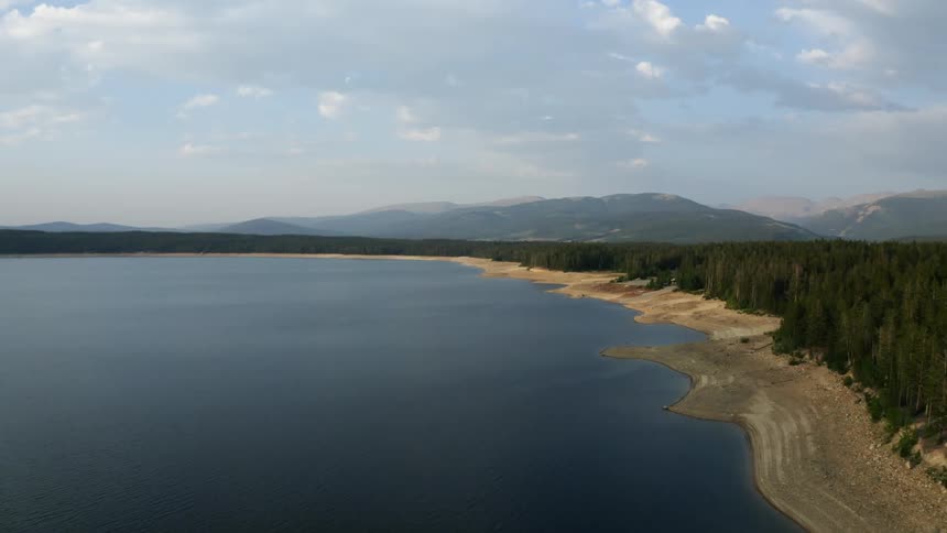 An aerial view of a lake on the edge of a forest