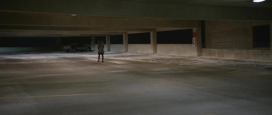 A woman walks through a parking lot