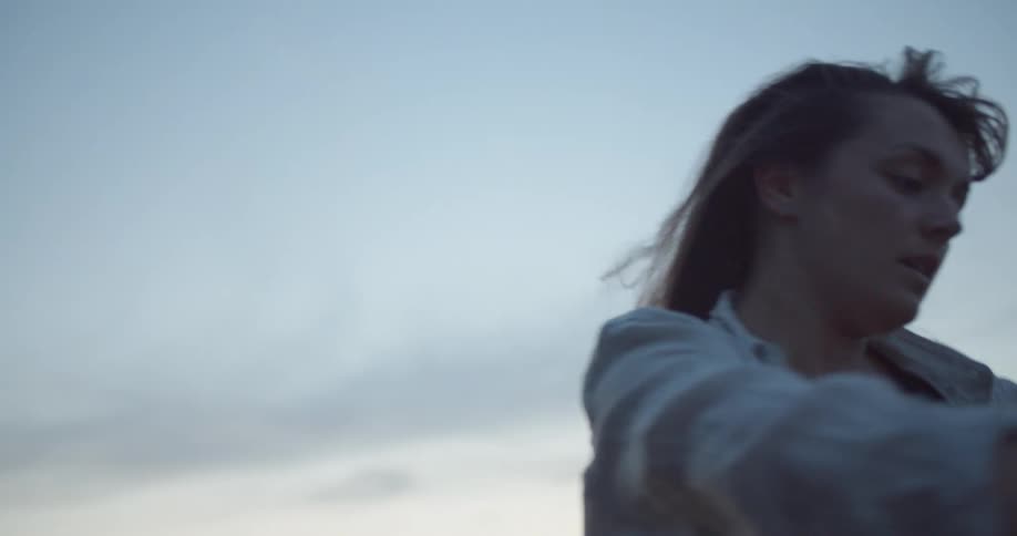 A woman is outside performing tai chi movements