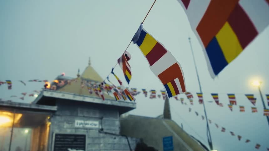Flags and banners on lines connected to roof of spire topped building wave in breeze