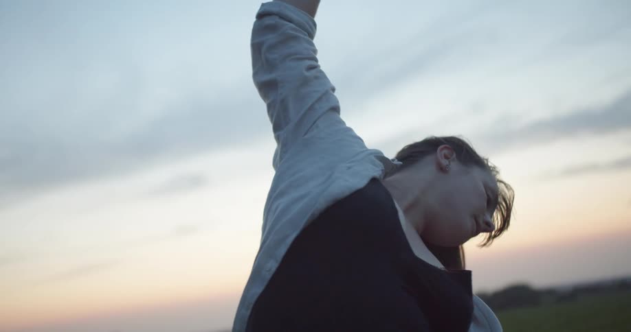 A woman is outside performing tai chi movements