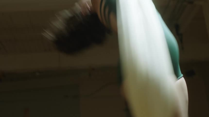 A female acrobat spinning and posing on suspended fabric