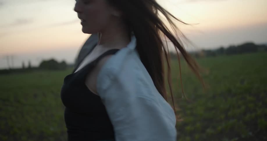 A woman is outside performing tai chi movements