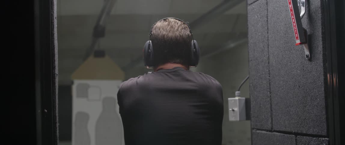 A person firing a gun at a shooting range