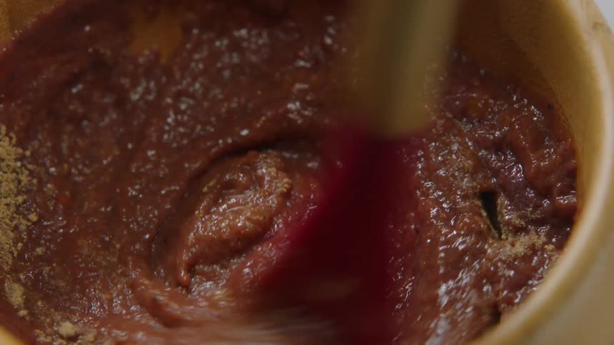 Sauce being mixed in a bowl with a spoon