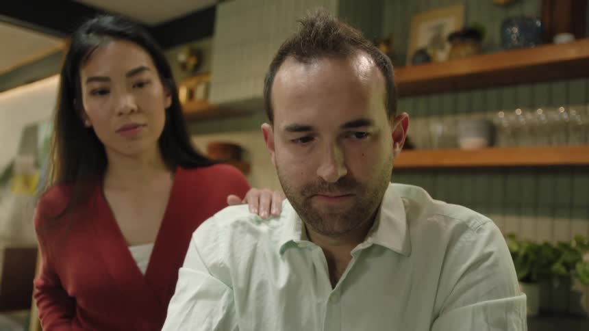 Mother checks to see how successful husband is in feeding child