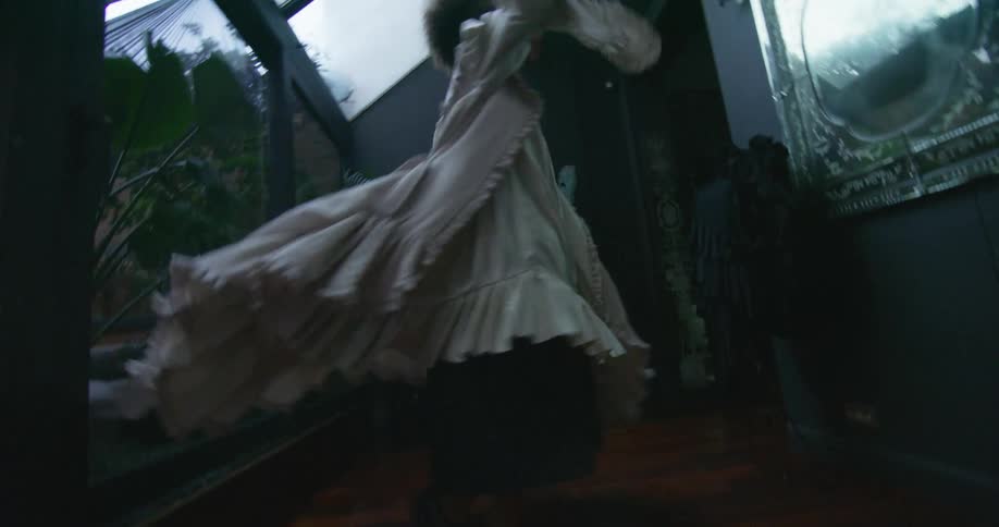 A woman is dressed up in a costume dress and dancing and spinning around