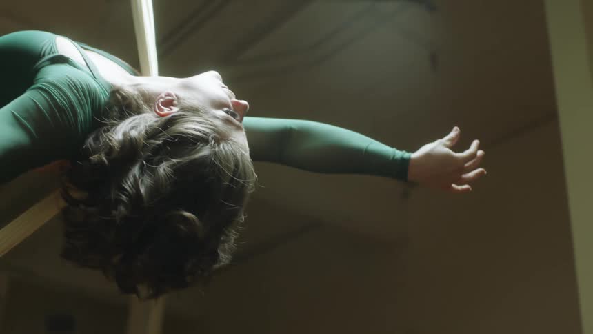 A woman is hanging from a sheet in the gym