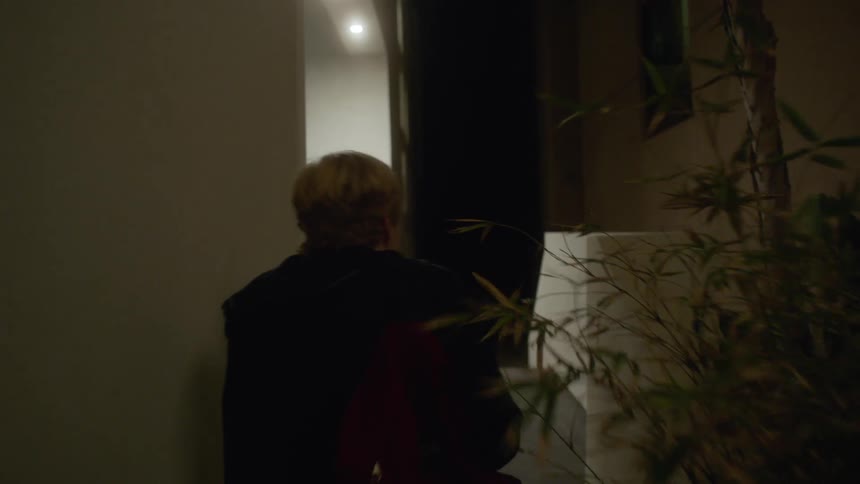 A man walks up some stairs then knocks on a door