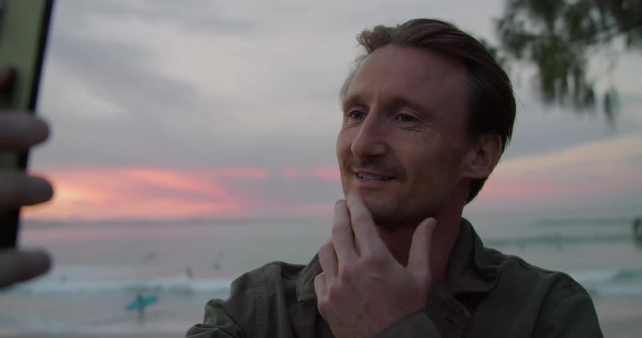 A man talks on his cell phone on the beach