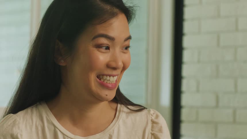 A young woman smiling and laughing indoors