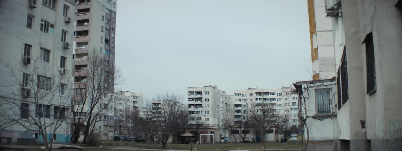 Person walks past apartment buildings