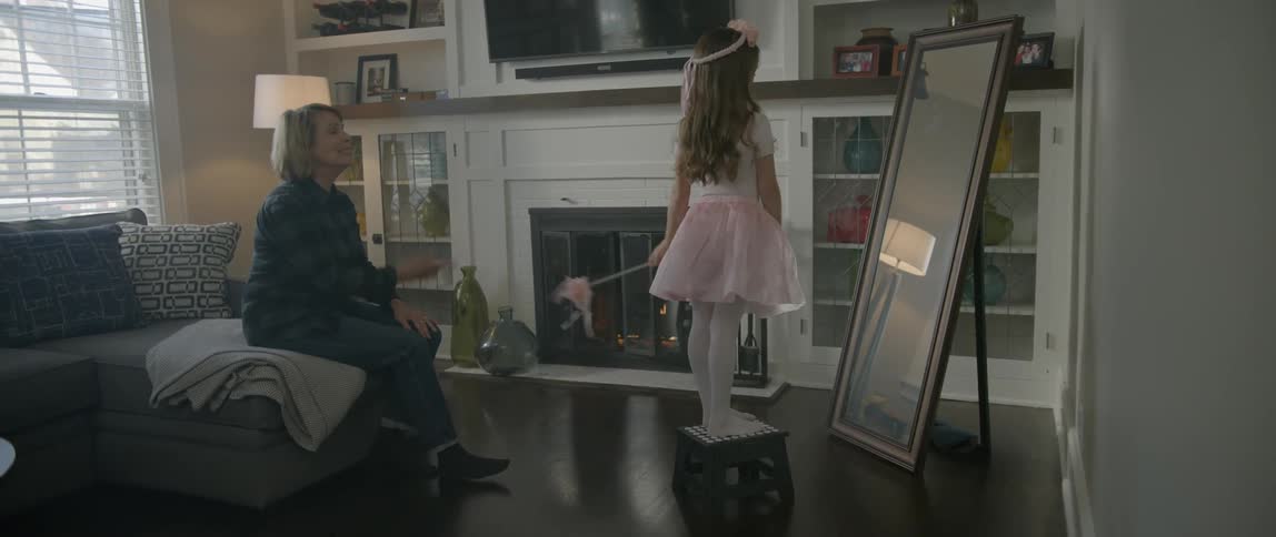 An older woman watches a girl in a fairy dress