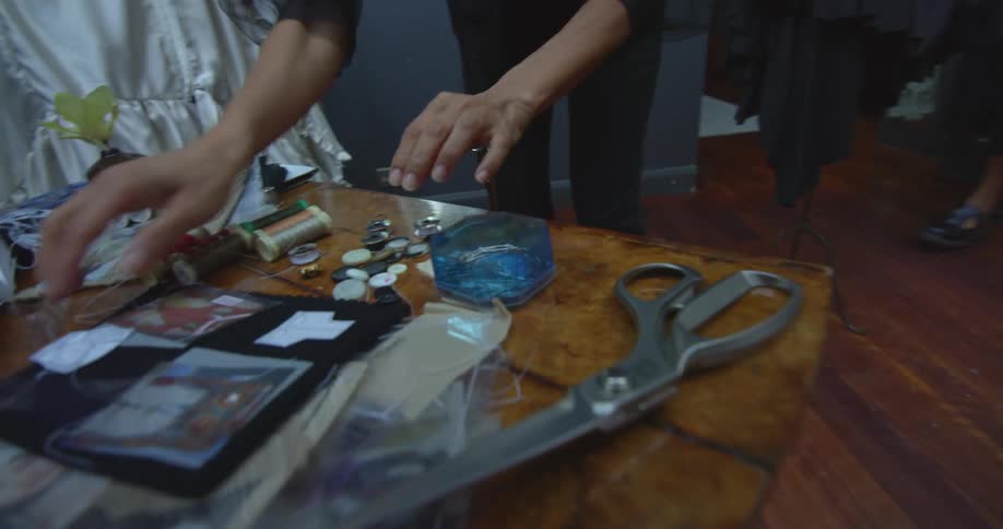 Designers move around studio selecting and organizing sewing materials