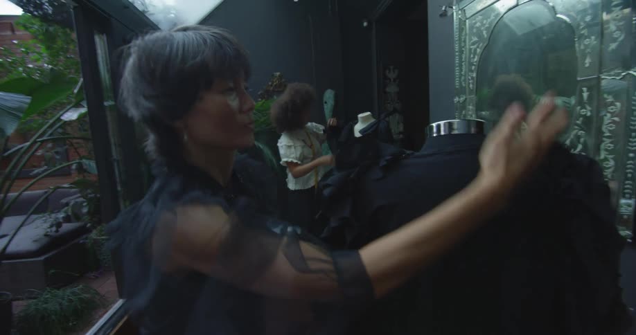 Two women are putting clothes on mannequins