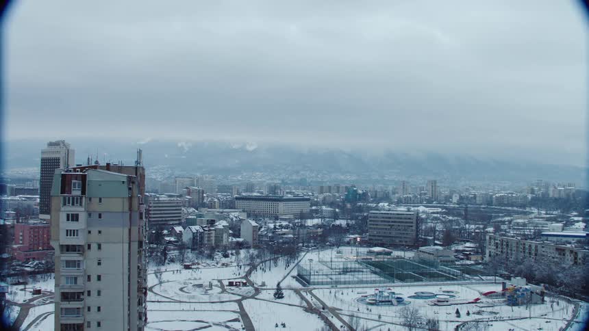 Aerial view of a snow covered city under a cloudy sky