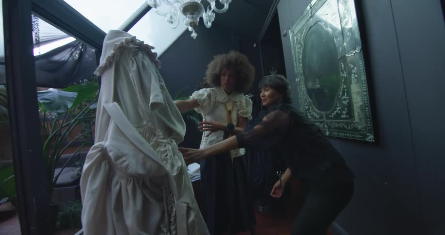 Two women looking at a dress in a shop