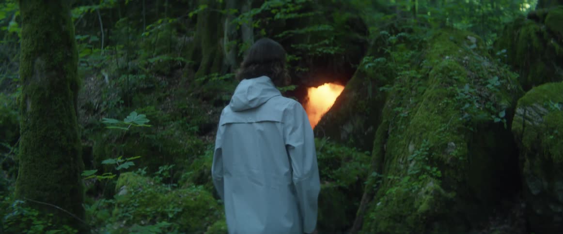 A man hikes towards the light in the cave