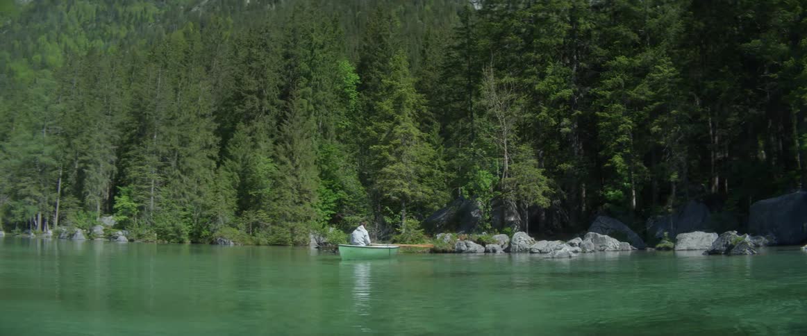A man is rowing a boat across the water